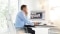 The image shows an employee working on a computer.